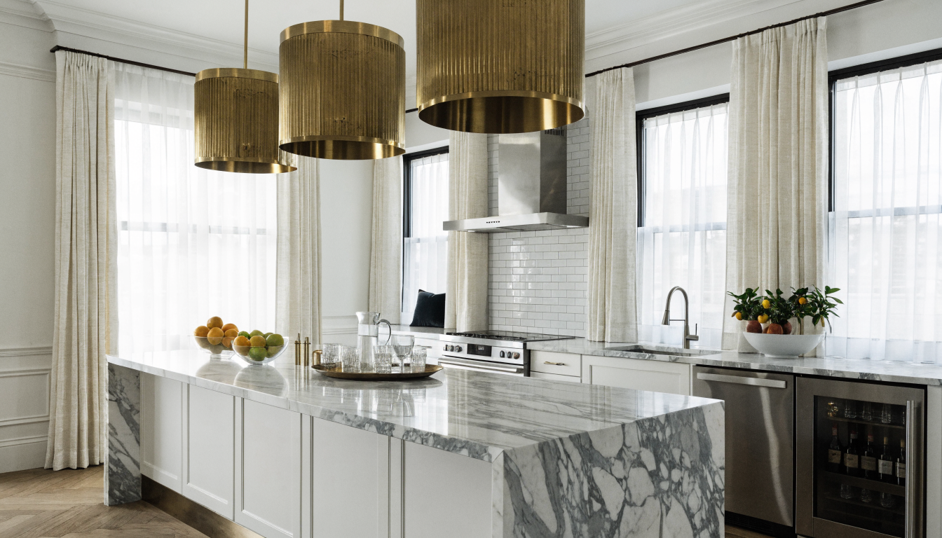 Modern white kitchen with marble waterfall island and brass pendant lights